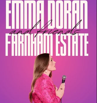 Comedian on stage at Farnham Estate comedy event, vibrant pink backdrop, holding microphone, lively entertainment venue.